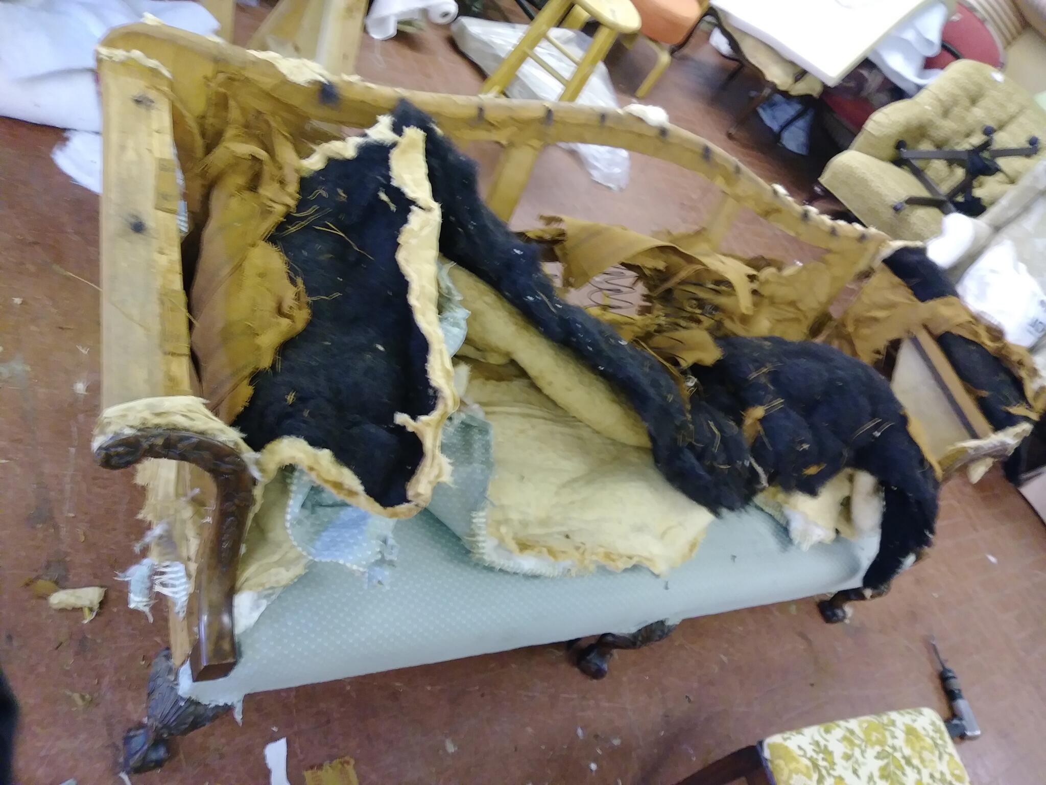 Upholstery removed to reveal a wooden furniture frame