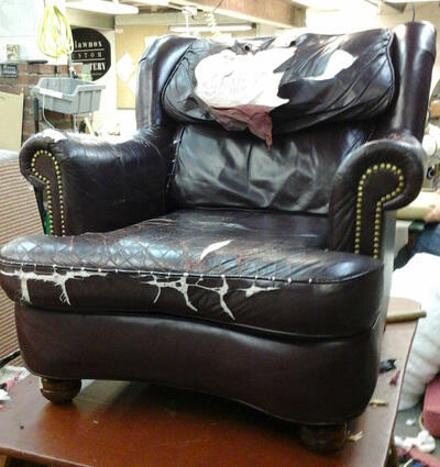 A worn leather armchair awaiting attention