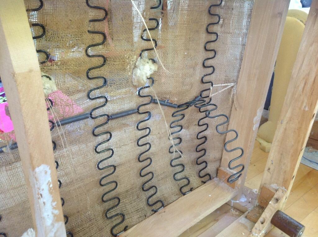 Close view of upholstery springs inside a wooden chair frame